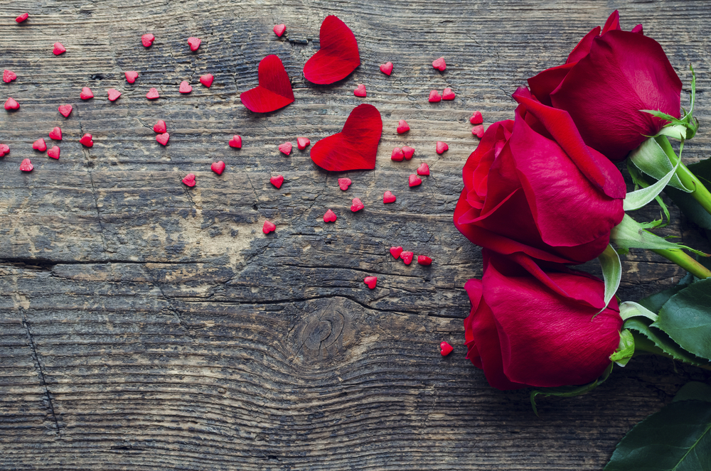 Rosen auf einem Holztisch an Valentinstag