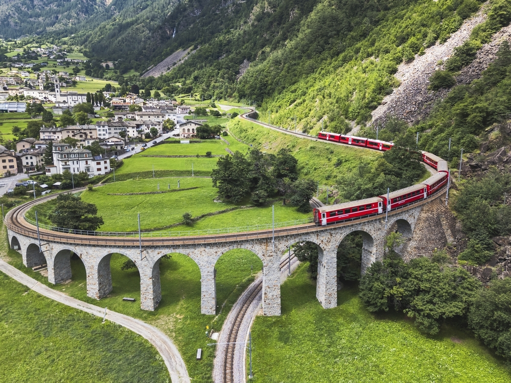 Blick auf die Luftaufnahmen eines Bernina-Express-Zuges über das Spiralviadukt Brusio der Rhätischen Bahn, Kanton Bündn, Schweiz