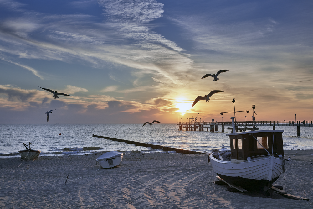 Boote am Strand bei Sonnenuntergang mit Möwen