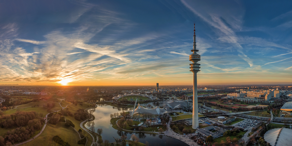 der Olympiapark in München als Luftaufnahme einer Drohne zum Sonnenuntergang im Herzen von München