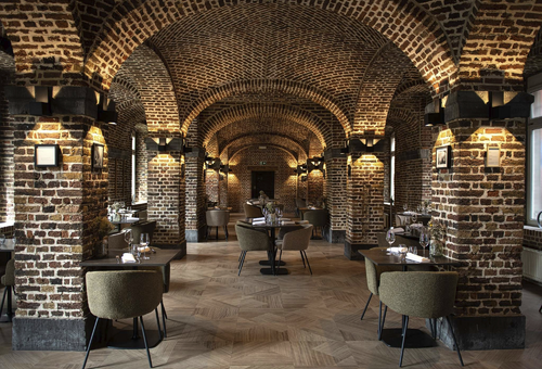 Ein elegantes Restaurant mit Backsteinwänden und Gewölbedecke.